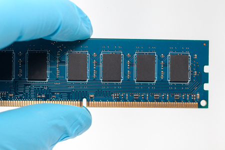 hand in blue glove holding ram memory on white backgroundの写真素材