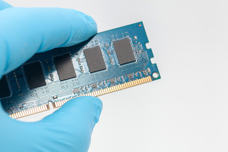 hand in blue glove holding ram memory on white backgroundの写真素材