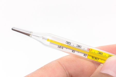 hand holding mercury thermometer on white background