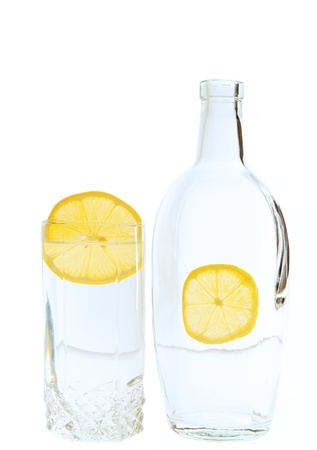 bottle and tumbler with lemon on white backgroundの写真素材