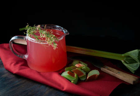 Rhubarb compote in glass vessel on red clothの写真素材