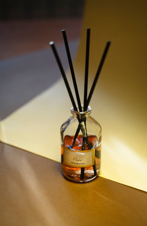 Aroma reed stick diffusor on brown and yellow background.の写真素材