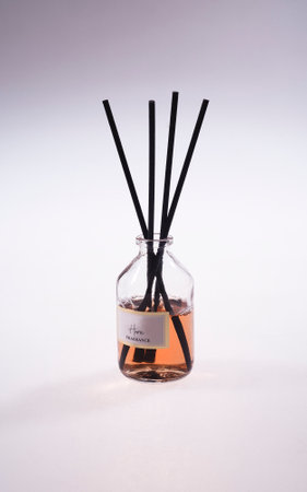 Aroma scent reed diffuser glass bottle is on the white table to creat romantic and relax ambient in the bedroom isolated on white cement wall background in the morning for happy valentine dayの写真素材