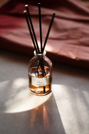 Aroma reed stick diffusor on gray table in the morning light.の写真素材