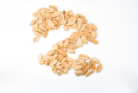 Pile of peanuts in \\\Z\\\ shape isolated on a white background, selective focus.