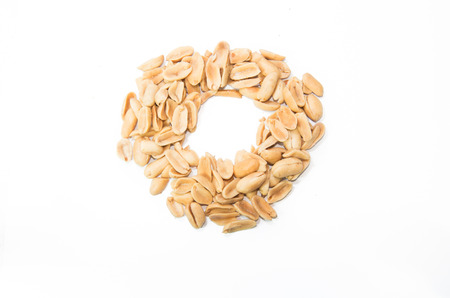 Pile of peanuts in \"O\" shape isolated on a white background, selective focus.の写真素材