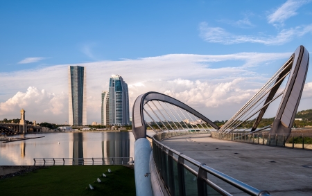Landscape of a modern curvy bridge by the lakesideの写真素材
