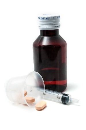 Bottle of medicine, pills and syringe isolated on whiteの写真素材