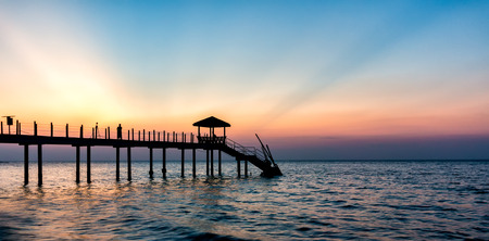 Colorful sunset at tropical beach with jettyの写真素材