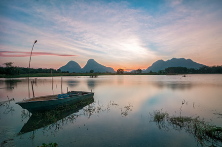 Lonely boat by the lakeside during beautiful sunset