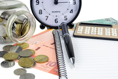 Business and finance concept.Pen,calculator,notepad and clock with money on white background.の写真素材