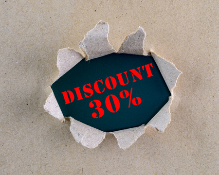 Torn brown rough textured paper with "Discount 30" words at background surface.の写真素材