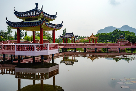 Beautiful garden with Chinese architecture bridge and reflection in the lakeの写真素材