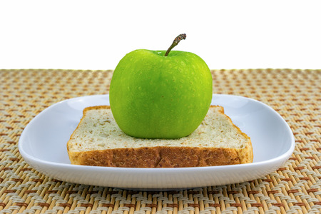 Apple and bread served on white plate. Healthy diet concept. Selective focus.の写真素材