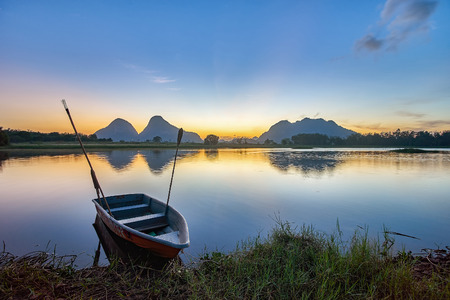 TIMAH TASOH PERLIS, MALAYSIA - DECEMBER 26,2015 : Beautiful reflection of sunrise with a boat by the lakeside in a summer day.のeditorial素材