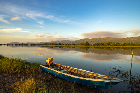 Beautiful morning at the lake with a fishing boat.の写真素材