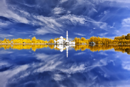 Beautiful view of mosque by the lakeside in infrared with full reflection.の写真素材