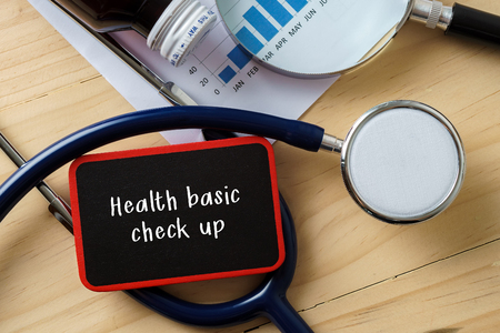 Medical conceptual.Stethoscope on wooden table with word HEALTH BASIC CHECK UP.の写真素材