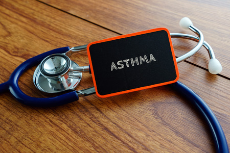 Medical concept.Word ASTHMA with stethoscope on wooden table.の写真素材