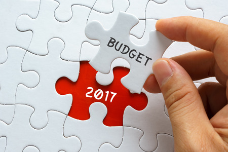 Hand holding jigsaw puzzle with word BUDGET 2017.の写真素材