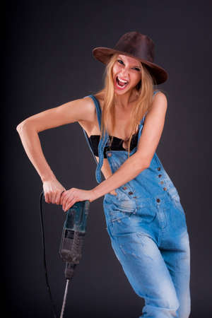 Girl with a drill in building overallsの写真素材
