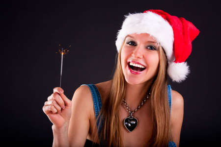 Cute girl in Santa hat holding sparklersの写真素材