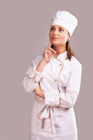 Young woman in white chef dress with hatの写真素材