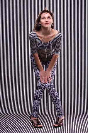 Cute girl in a striped clothes on the striped backgroundの写真素材