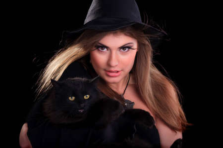 Beautiful girl dressed as a witch holding catの写真素材