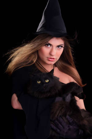 Beautiful girl dressed as a witch holding catの写真素材