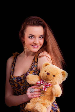 Beautiful longhair girl is holding the teddy bearの写真素材
