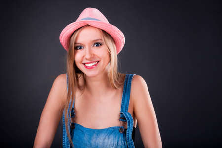 Pretty girl in pink hat and jeans overallsの写真素材