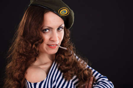 Emotional portrait of a girl in a vest and a military beretの写真素材