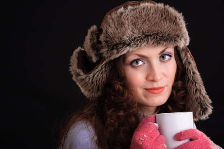 Romantic image of beautiful woman in a fur hat with a cupの写真素材