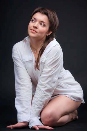 Young sexy brunette woman posing in white shirtの写真素材