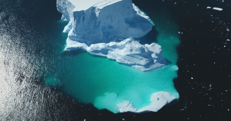 Huge iceberg floating in turquoise frozen ocean water. Antarctica majestic melting glacier...