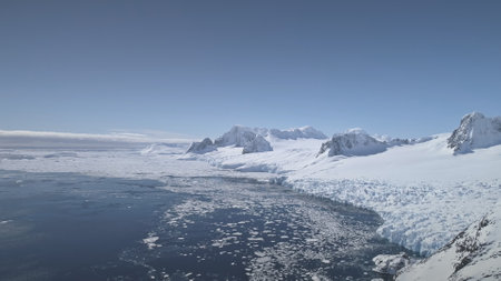 Aerial flight over Antarctica glacier shoreline. Climate change. Snow, ice covered mountains land....