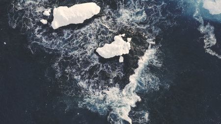 Icebergs Among Antarctica Ocean. Top Down Aerial Flight Over Ice Cold Polar Water. Zooming Out Shot...