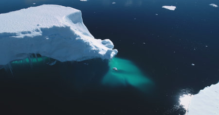 Melting glacier in Antarctica, aerial drone panorama. Huge iceberg float ocean water. Polar climate...