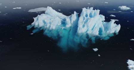 Antarctica melting iceberg reflection at blue ocean water aerial view. Antarctic nature landscape...