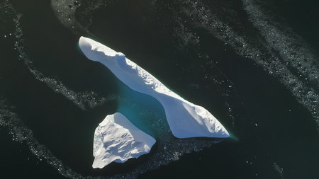 Antarctica iceberg aerial drone view flight. Fast top down. Overview the lone snow white ice...