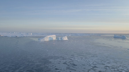 Drone aerial view over Antarctic ocean water surface. Floating ice and icebergs. Antarctica Coast...