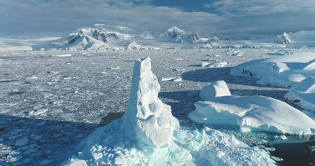 Aerial panorama towering iceberg in Antarctica. Frozen ice floes ocean, snow covered mountains blue...