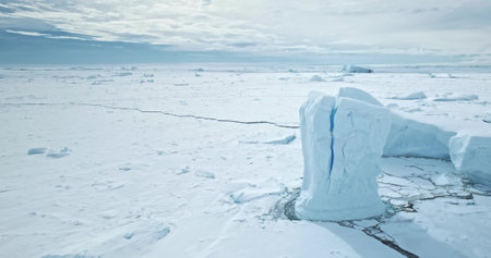 Antarctica cracked iceberg towering frozen ocean. Huge snow covered ice glacier in wild nature...