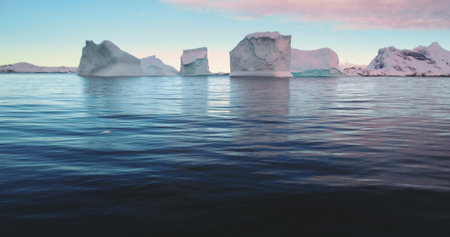 Many icebergs drifting ocean sunset Antarctica landscape. Wild nature winter scene, colorful evening sky. Environment ecological issue of global warming, climate change. Travel background. Static shotの写真素材