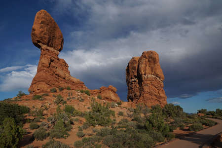 Balanced Rock in Arches National Park with dark stormy clouds rolling in, daytime. Famous landmark inside Arches National Park in Moab, Utah, USA.の写真素材