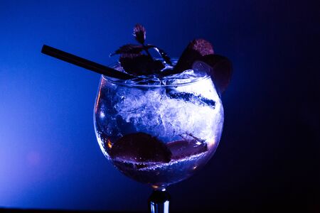 Refreshing Gin and Tonic in a club with ice drops and blue backlightのeditorial素材