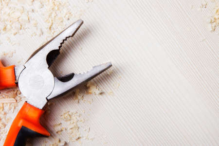 Construction pliers on a wooden Board. copy space