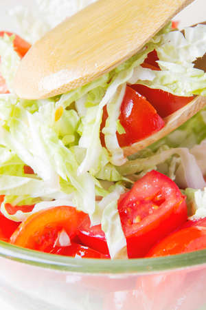 Fresh salad of cabbage and tomato. Salad with olive oil. fresh sliced vegetables. food background closeupの写真素材