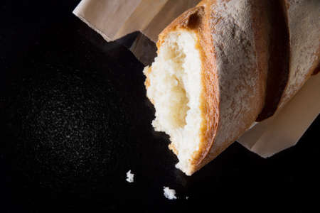 Baguette on dark background closeup. food background top view
